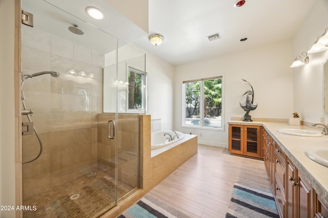 bathroom with hardwood / wood-style floors, vanity, and separate shower and tub