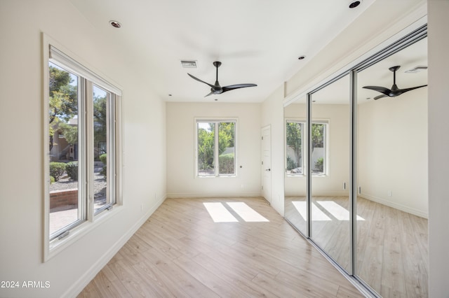 unfurnished bedroom with multiple windows, ceiling fan, and light hardwood / wood-style flooring