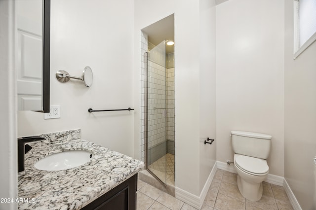 bathroom with tile patterned flooring, vanity, toilet, and walk in shower