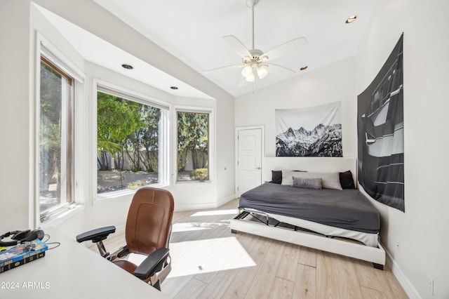 bedroom with light hardwood / wood-style flooring, ceiling fan, and lofted ceiling