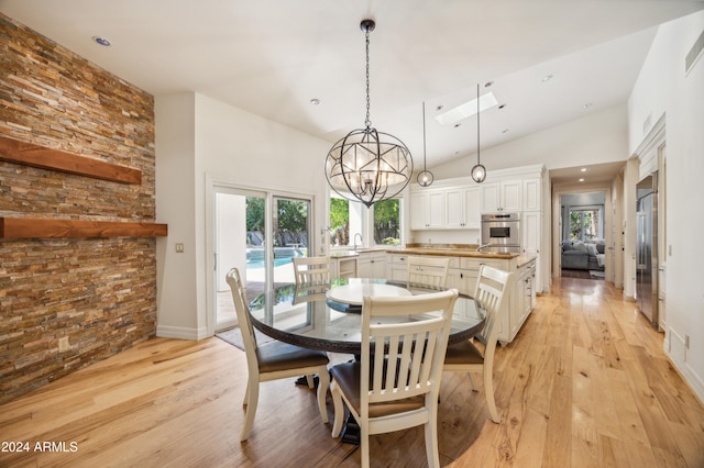 dining room with plenty of natural light, light hardwood / wood-style floors, and high vaulted ceiling