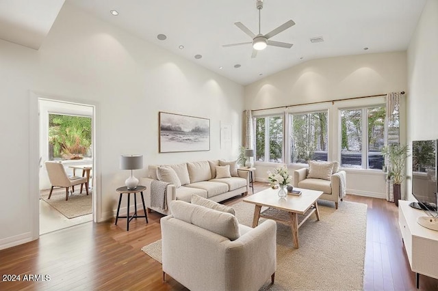 living room with ceiling fan, plenty of natural light, high vaulted ceiling, and hardwood / wood-style flooring