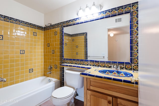 full bathroom with vanity, tiled shower / bath, tasteful backsplash, and toilet