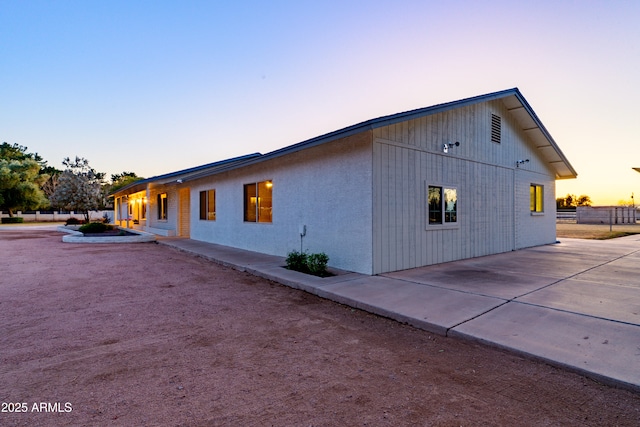 property exterior at dusk with a patio area