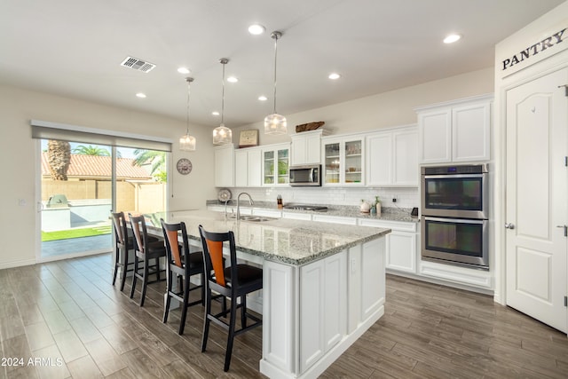 kitchen featuring pendant lighting, white cabinetry, stainless steel appliances, and dark hardwood / wood-style floors