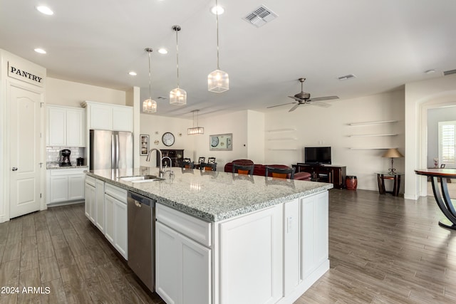 kitchen with white cabinets, appliances with stainless steel finishes, sink, an island with sink, and dark wood-type flooring