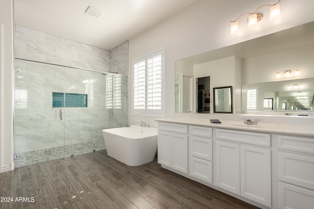 bathroom with shower with separate bathtub, hardwood / wood-style floors, and vanity