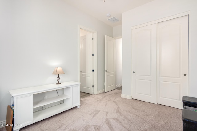 bedroom with light colored carpet and a closet