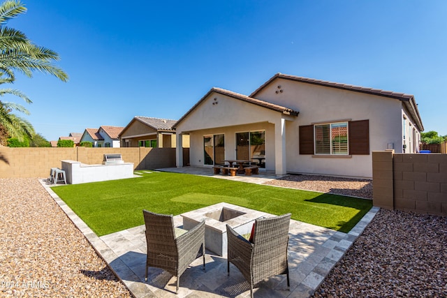 back of property with a patio area and a yard