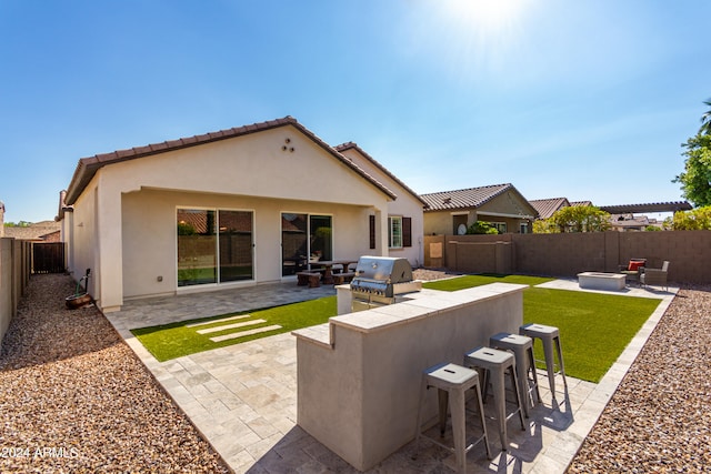 rear view of property with area for grilling, an outdoor bar, and a patio area