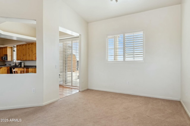 unfurnished room with light carpet and baseboards