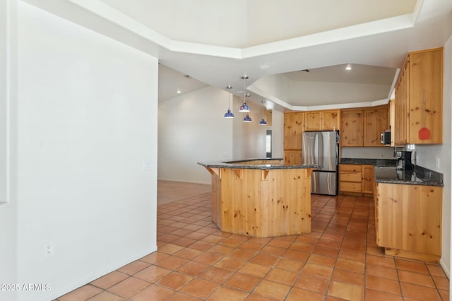 kitchen with freestanding refrigerator, a breakfast bar, a raised ceiling, and recessed lighting