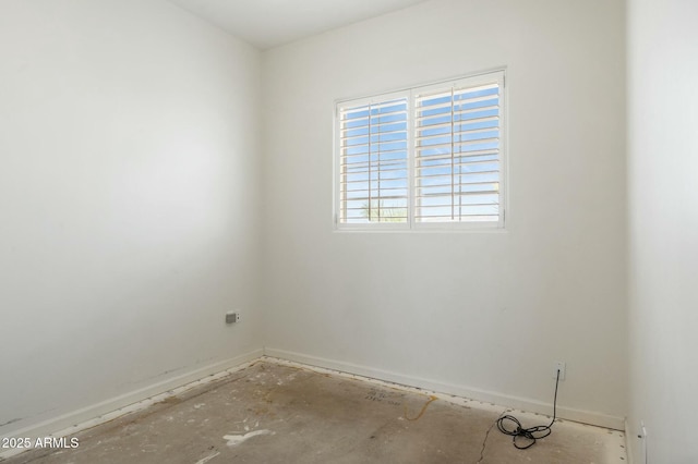 unfurnished room with baseboards