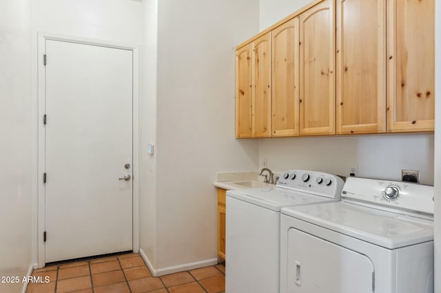 washroom with light tile patterned floors, cabinet space, a sink, baseboards, and washing machine and dryer