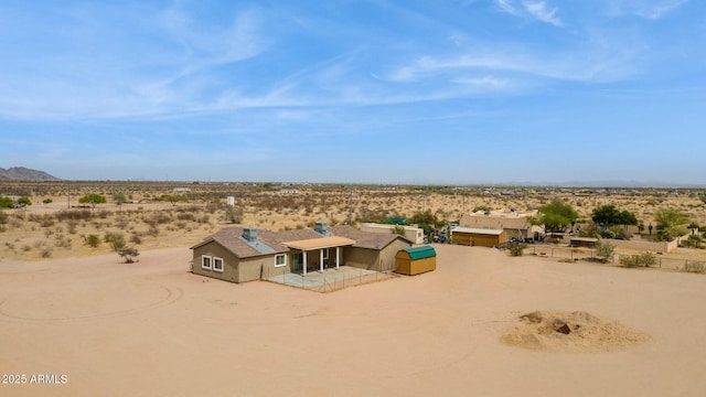 drone / aerial view featuring a mountain view, a desert view, and a rural view