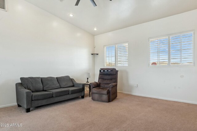 living area featuring baseboards, carpet, vaulted ceiling, and a ceiling fan