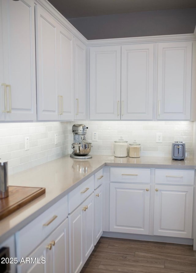 kitchen with dark wood-style floors, light countertops, white cabinetry, and decorative backsplash