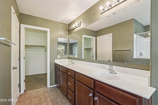 2947 N Evergreen St, Buckeye, AZ 85396 - bathroom with double vanity, a stall shower, a walk in closet, and tile patterned floors