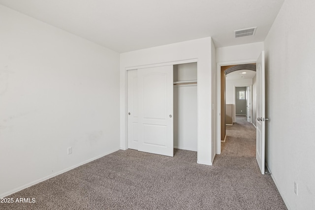 2947 N Evergreen St, Buckeye, AZ 85396 - unfurnished bedroom featuring arched walkways, carpet flooring, and a closet