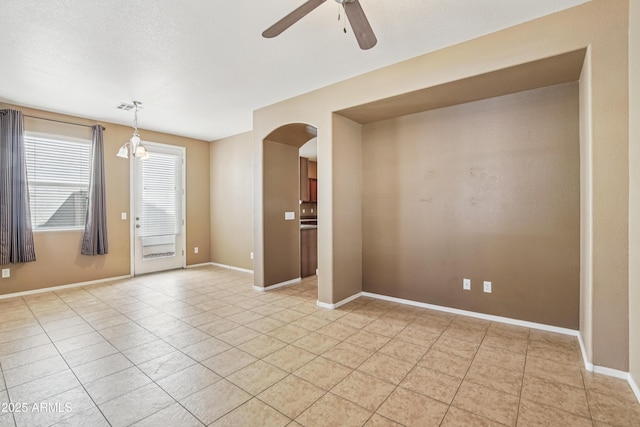 2947 N Evergreen St, Buckeye, AZ 85396 - empty room featuring light tile patterned flooring, a ceiling fan, and arched walkways