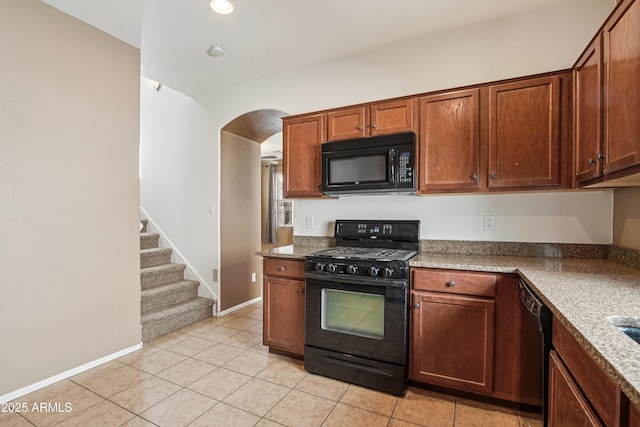 2947 N Evergreen St, Buckeye, AZ 85396 - kitchen featuring black appliances, arched walkways, light tile patterned floors, and brown cabinets