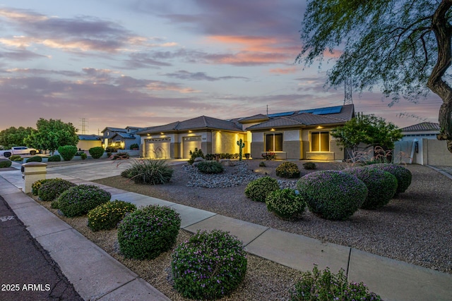 8132 W Hatfield Rd, Peoria, AZ 85383 - prairie-style home with driveway, an attached garage, solar panels, and stucco siding