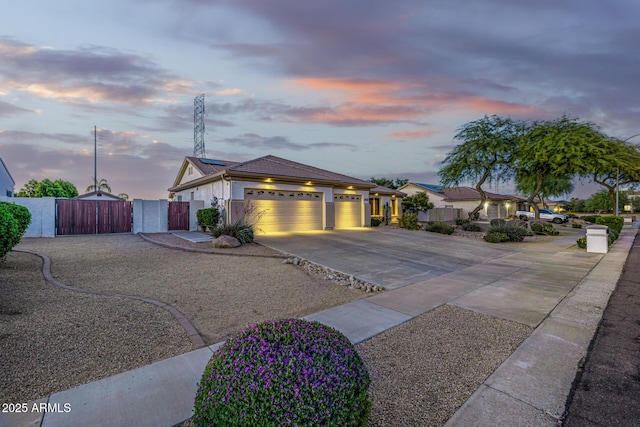 8132 W Hatfield Rd, Peoria, AZ 85383 - view of front of property featuring a gate, driveway, an attached garage, roof mounted solar panels, and stucco siding