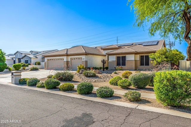 8132 W Hatfield Rd, Peoria, AZ 85383 - view of front of property with an attached garage, concrete driveway, roof mounted solar panels, a tile roof, and stucco siding