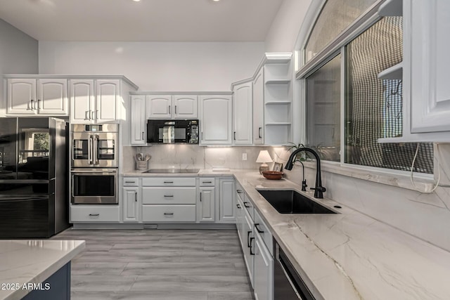 8132 W Hatfield Rd, Peoria, AZ 85383 - kitchen with black appliances, open shelves, white cabinetry, light stone counters, and tasteful backsplash