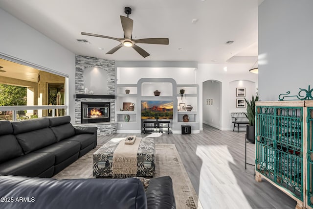 8132 W Hatfield Rd, Peoria, AZ 85383 - living area featuring a ceiling fan, arched walkways, a fireplace, wood finished floors, and built in features