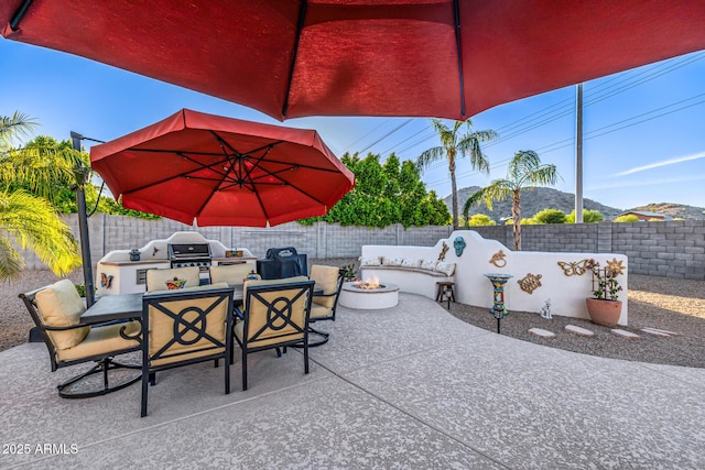 8132 W Hatfield Rd, Peoria, AZ 85383 - fenced backyard with a fire pit, an outdoor kitchen, a patio, outdoor dining space, and a mountain view