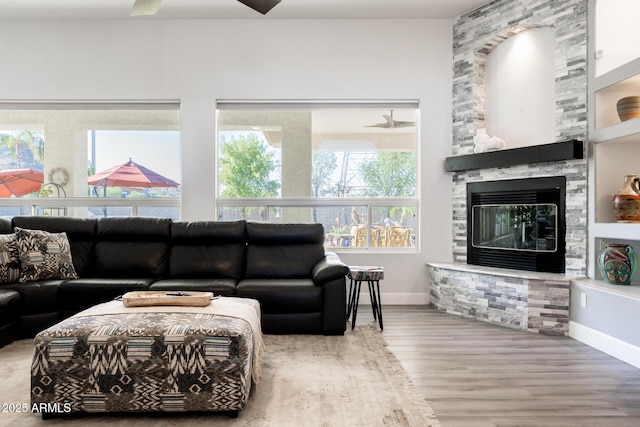 8132 W Hatfield Rd, Peoria, AZ 85383 - living area featuring wood finished floors, a stone fireplace, and healthy amount of natural light