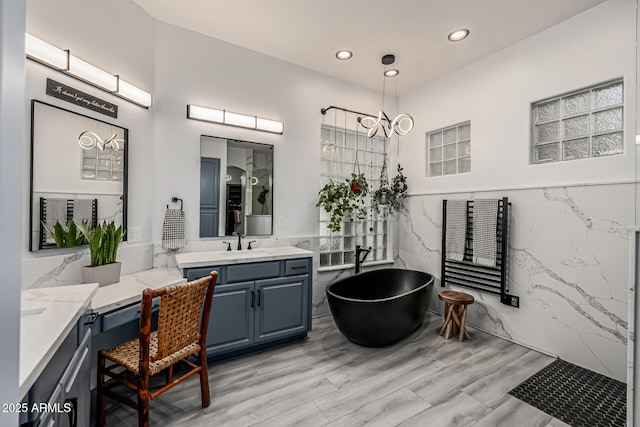 8132 W Hatfield Rd, Peoria, AZ 85383 - full bath with vanity, a soaking tub, wood finished floors, recessed lighting, and a towel warmer