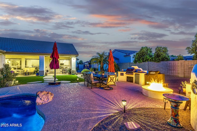 8132 W Hatfield Rd, Peoria, AZ 85383 - pool at dusk featuring an outdoor fire pit, area for grilling, a patio area, and a fenced backyard