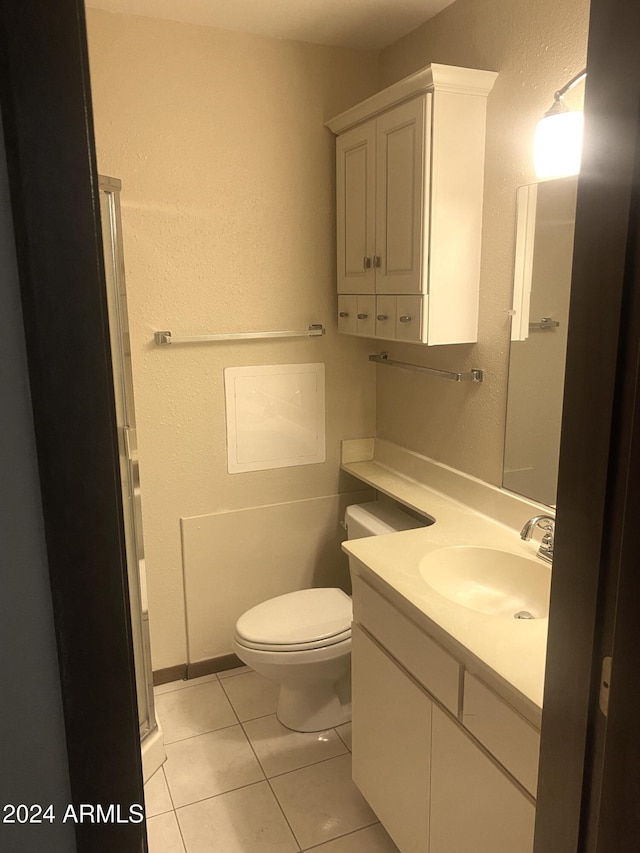 bathroom with tile patterned flooring, vanity, and toilet