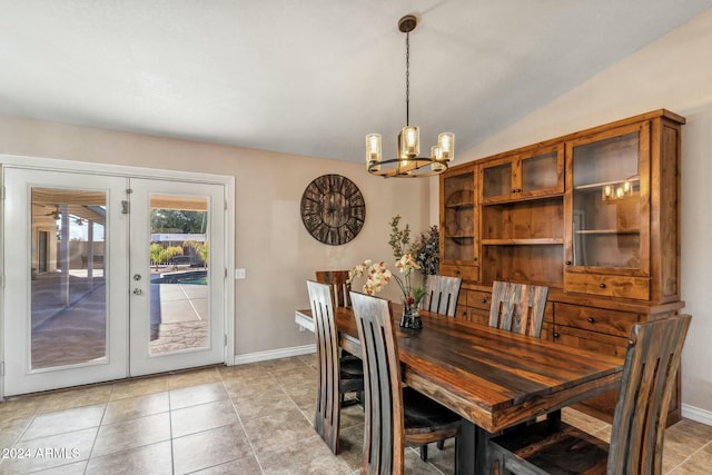 tiled dining space with french doors, an inviting chandelier, and vaulted ceiling