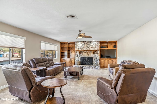 living room with plenty of natural light, ceiling fan, built in features, and a fireplace