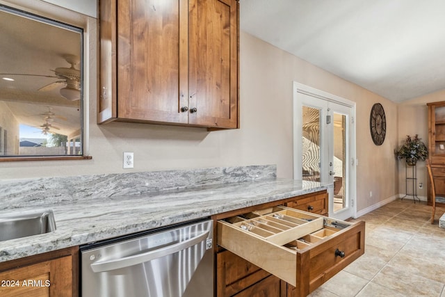 kitchen with ceiling fan, light stone counters, stainless steel dishwasher, vaulted ceiling, and light tile patterned flooring