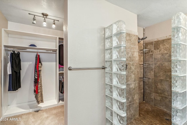 bathroom featuring a tile shower and a textured ceiling