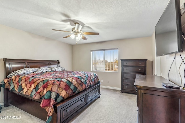 carpeted bedroom featuring a textured ceiling and ceiling fan