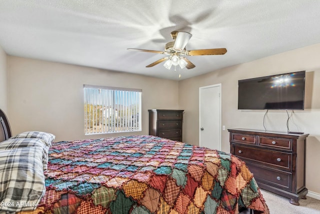 carpeted bedroom with ceiling fan and a textured ceiling