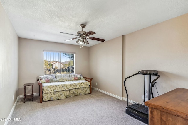 sitting room with ceiling fan, carpet floors, and a textured ceiling