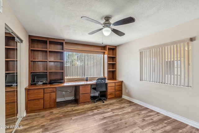 unfurnished office with a textured ceiling, hardwood / wood-style flooring, and ceiling fan