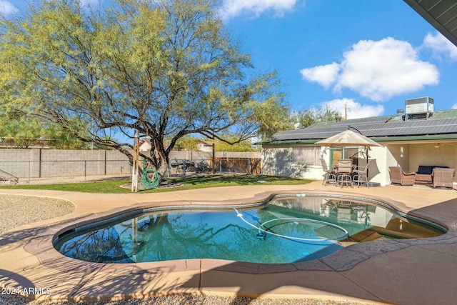 view of pool featuring cooling unit and a patio area