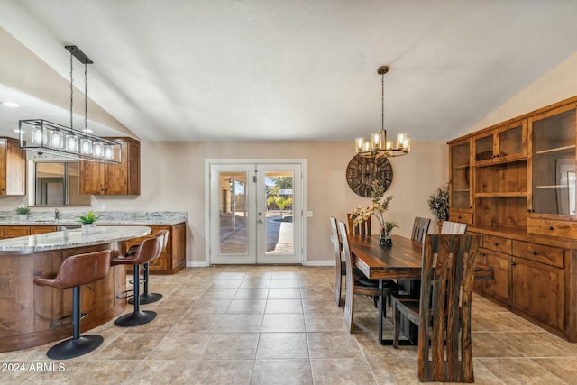 dining space featuring french doors, sink, a chandelier, and vaulted ceiling