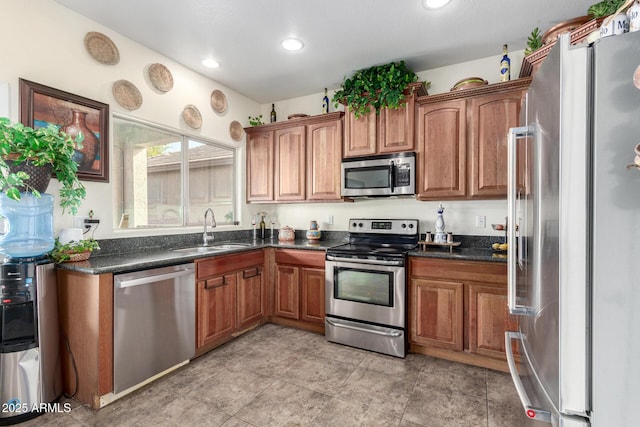 kitchen with sink, stainless steel appliances, and dark stone counters