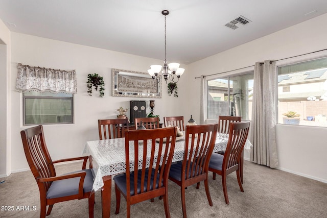 carpeted dining space with a chandelier