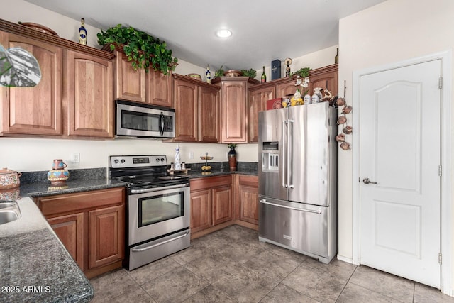 kitchen featuring appliances with stainless steel finishes and dark stone counters