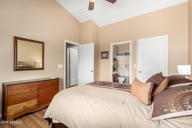 bedroom featuring vaulted ceiling, connected bathroom, ceiling fan, and light wood-type flooring