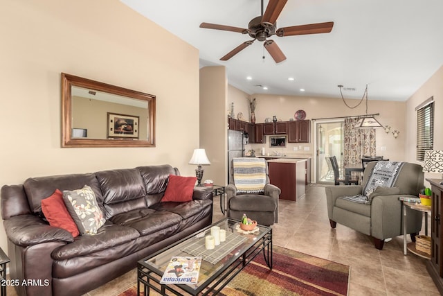 living room with lofted ceiling, light tile patterned floors, and ceiling fan